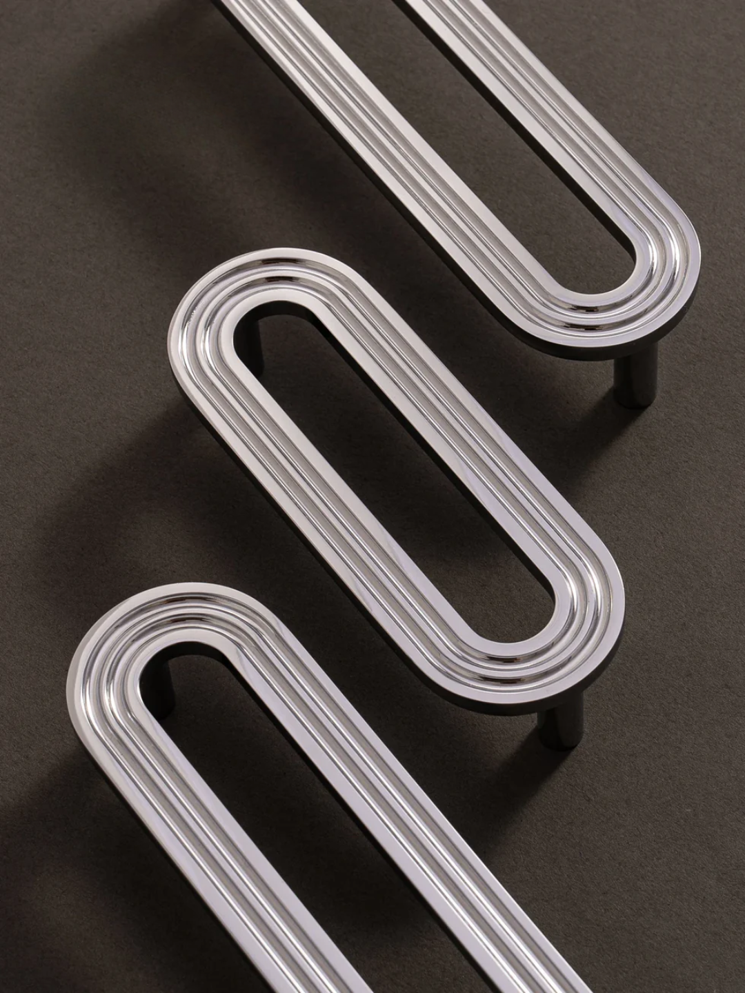 Three metallic U-shaped objects on a dark surface