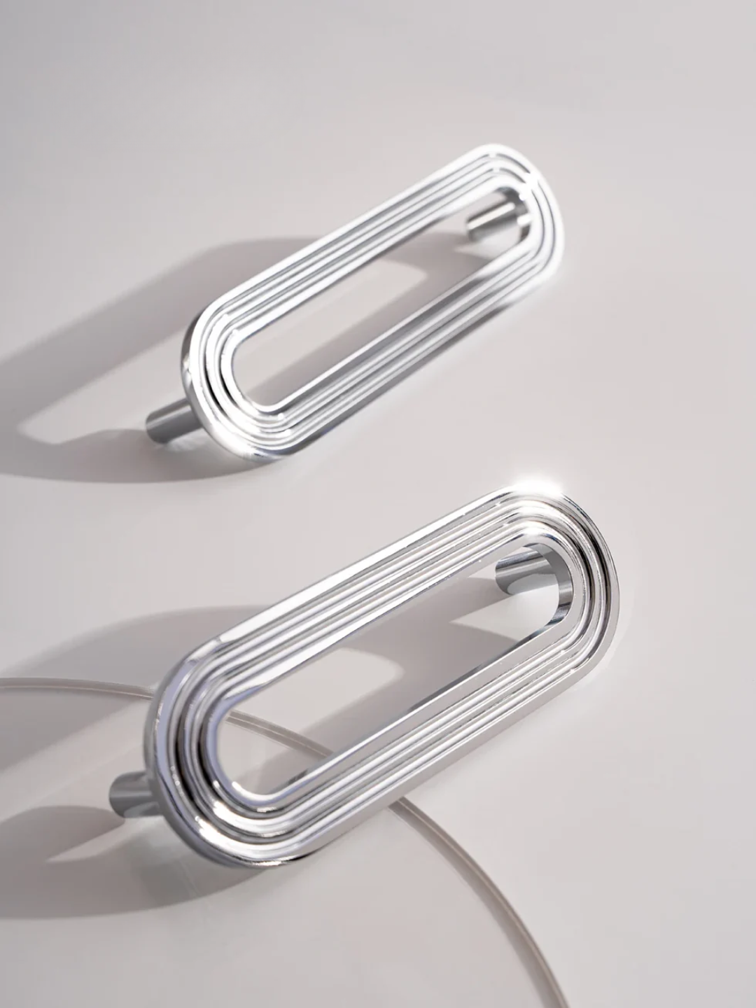 Two metallic handles on a light gray background
