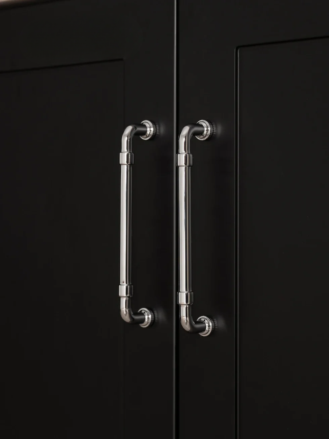 Black cabinet with metallic handles on a dark background