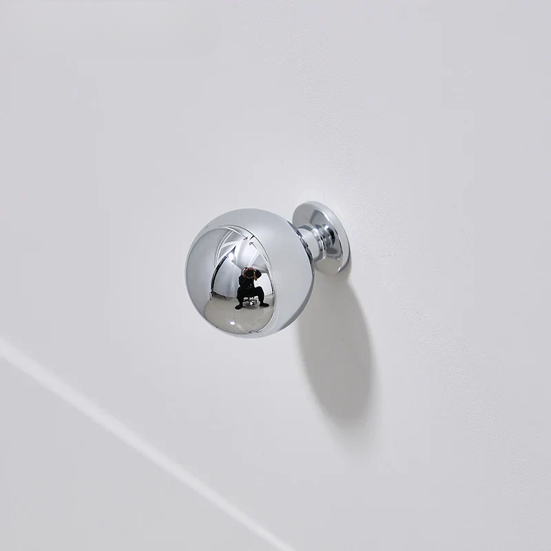 Chrome door handle on a white surface