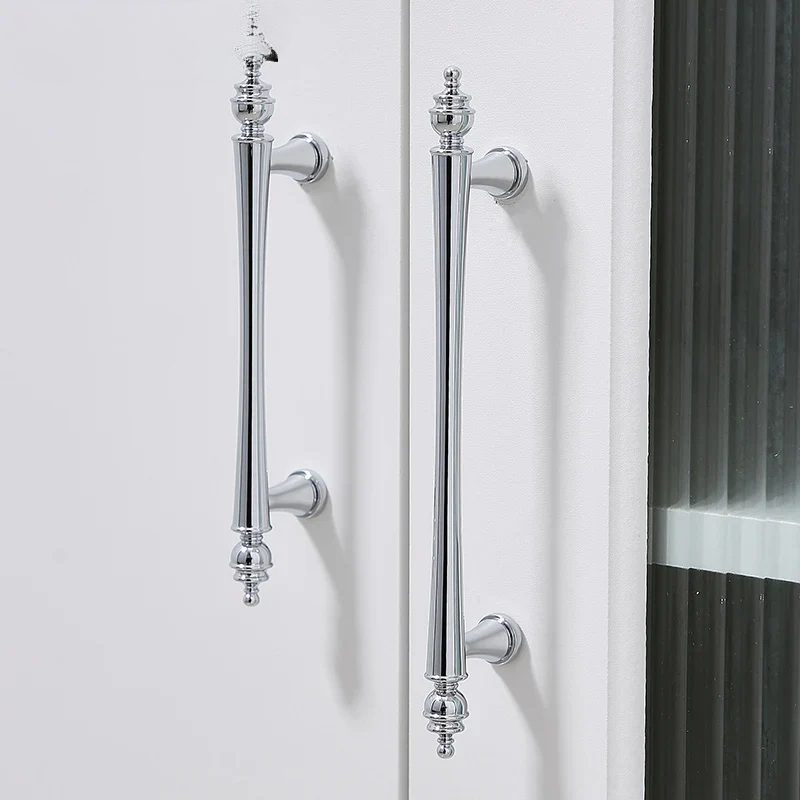 Chrome door handles on a white door with a black radiator in the background