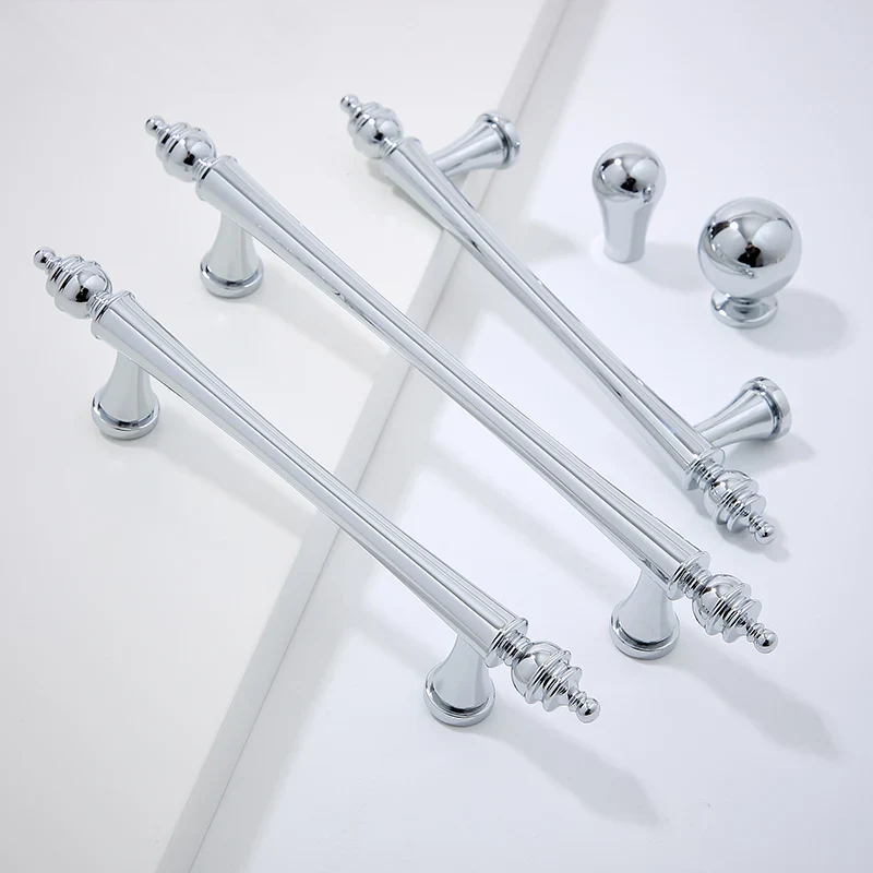 Set of chrome cabinet handles on a white background