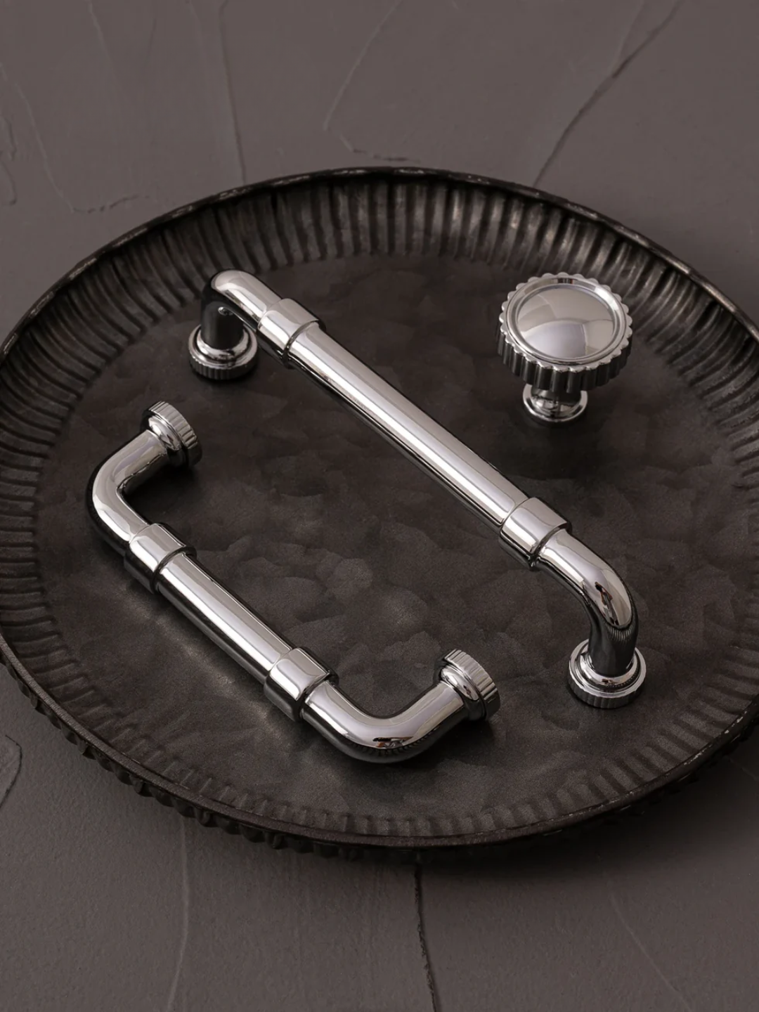 Metallic door handle and knobs on a textured black surface