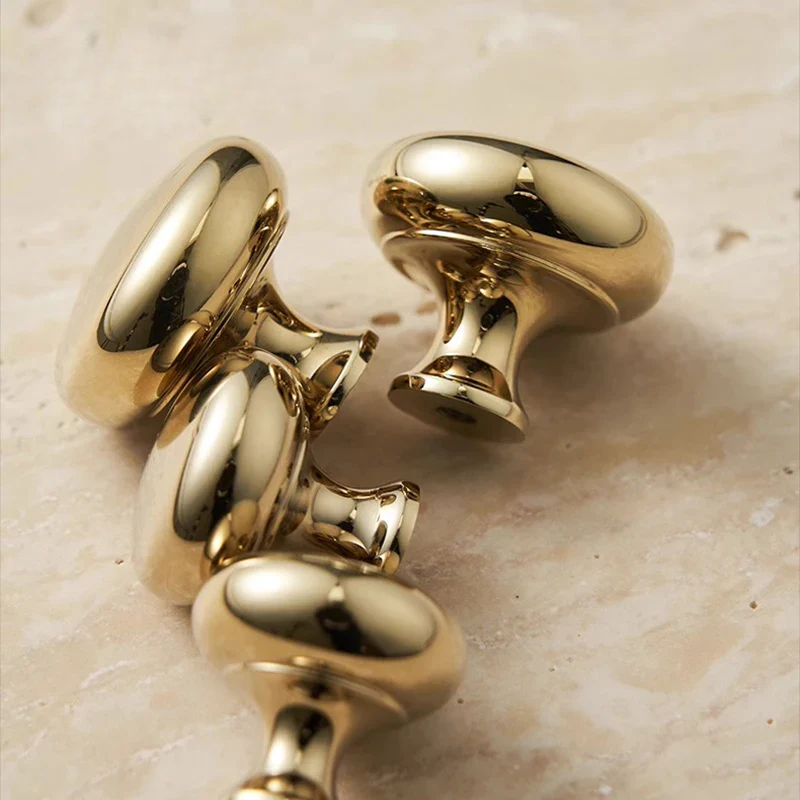 Gold cufflinks on a beige marble surface