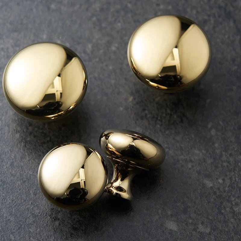 Set of gold spherical cufflinks on a dark textured background