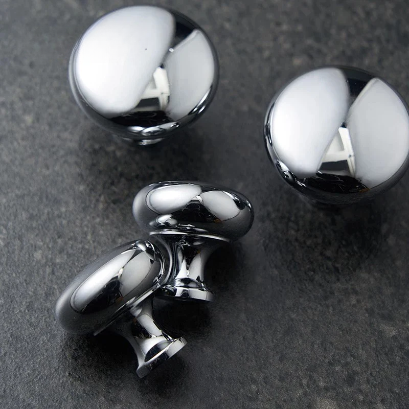 Close-up of three metallic knobs on a dark surface