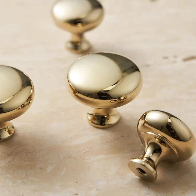 Gold cabinet knobs on a beige surface