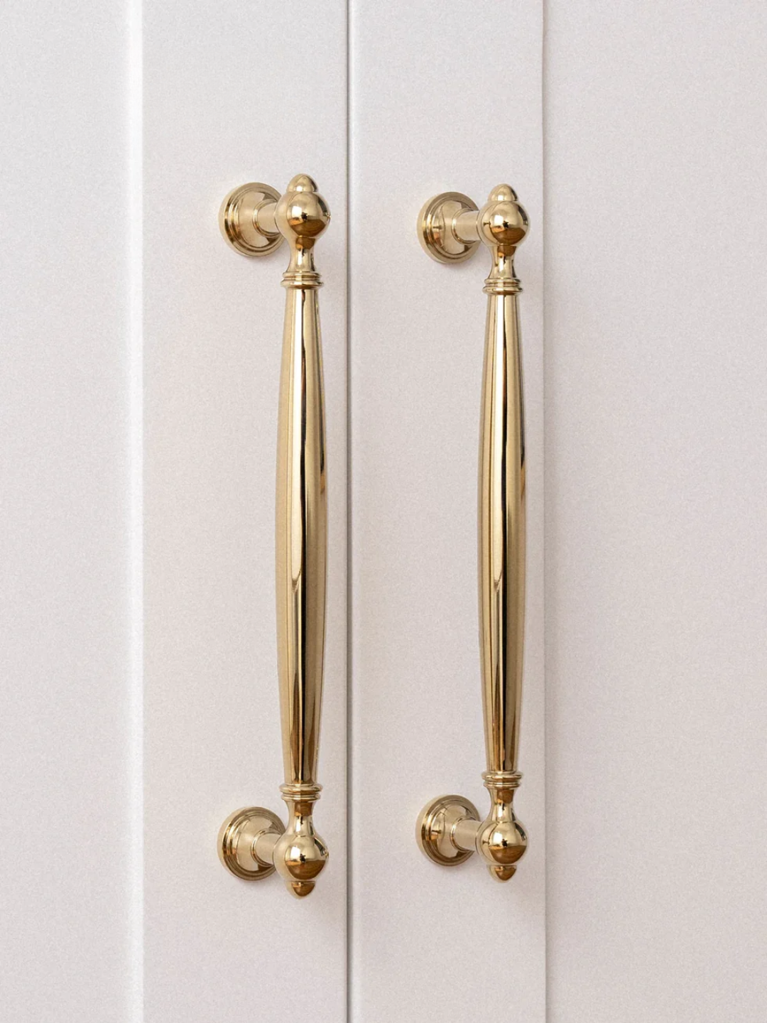 Gold cabinet handles on a white door