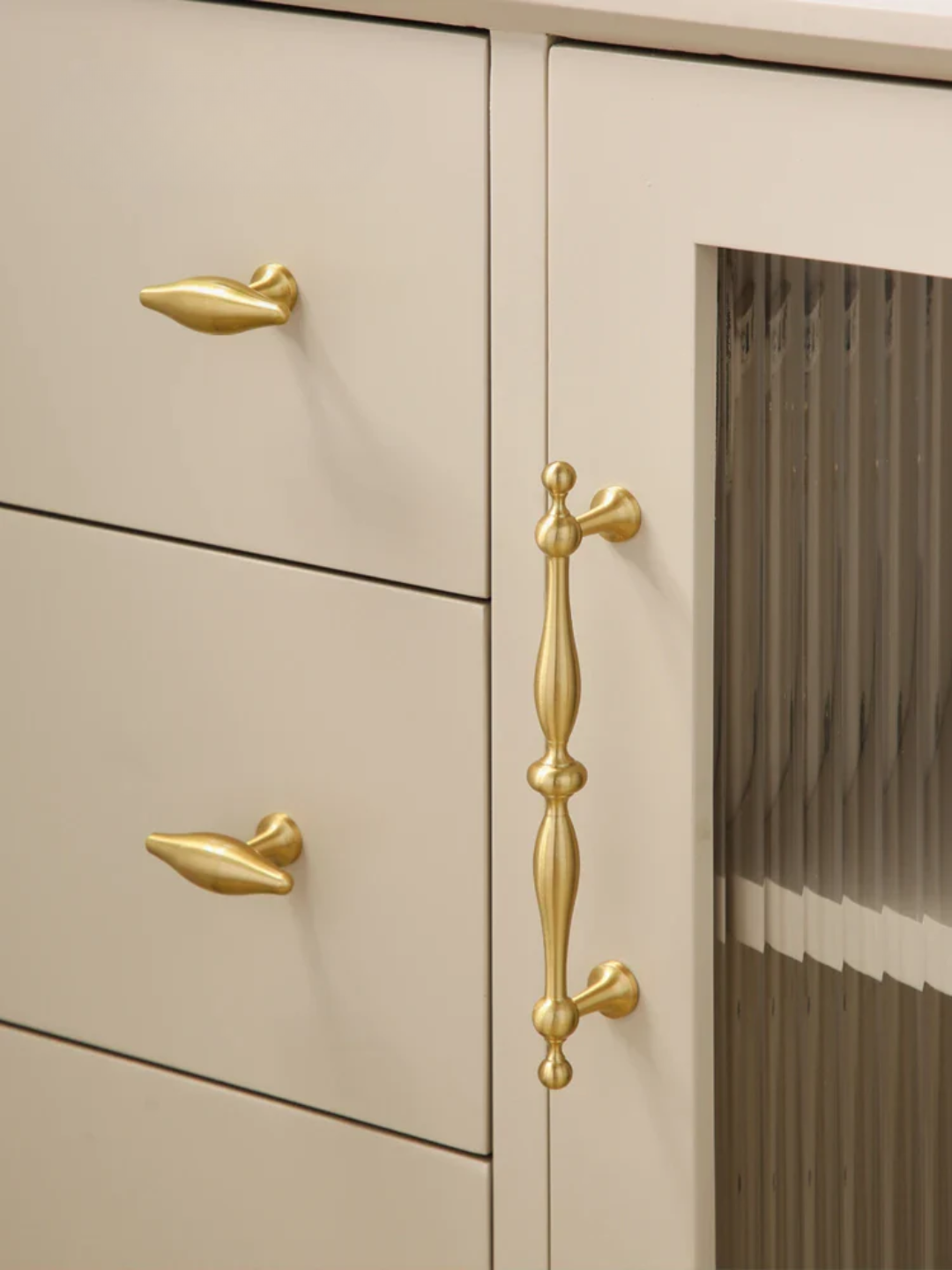 Beige cabinet with gold handles in a kitchen setting