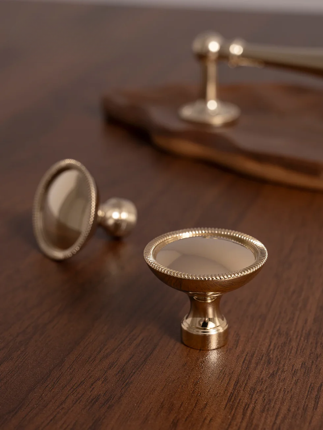 Gold cabinet knobs on a wooden surface