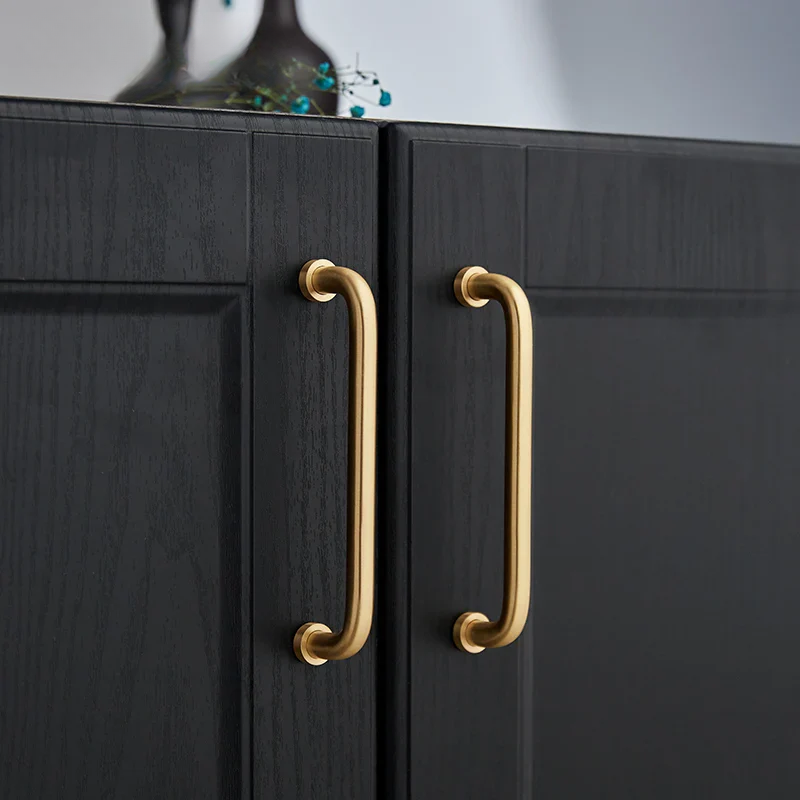 Black cabinet with gold handles on a neutral background