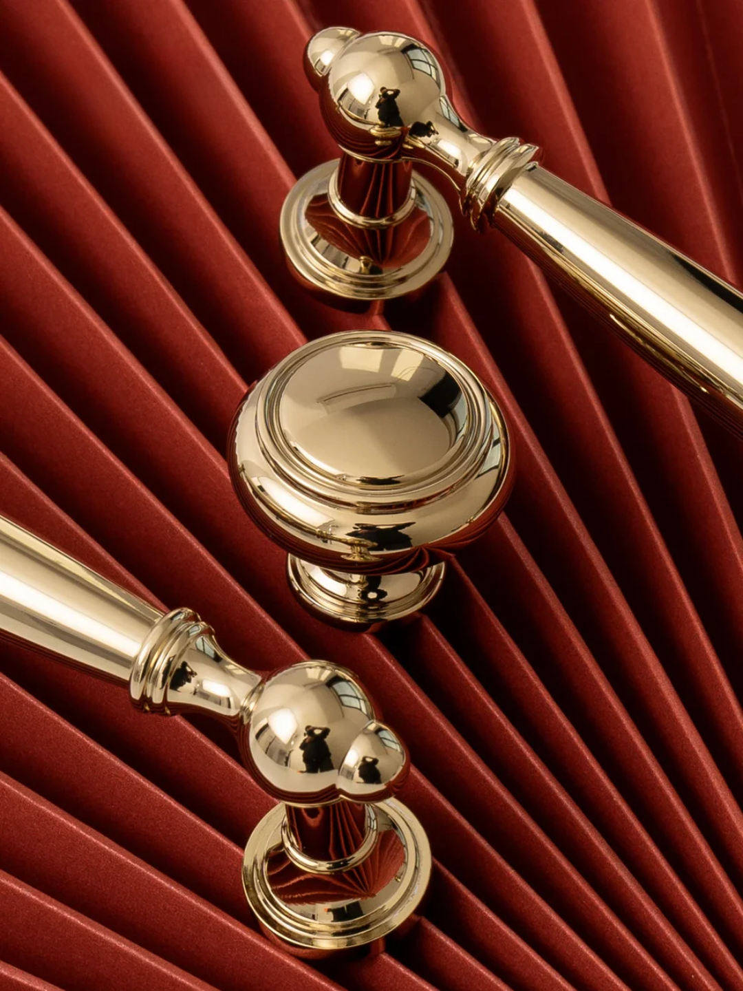 Gold curtain rods with decorative finials on a red curtain background