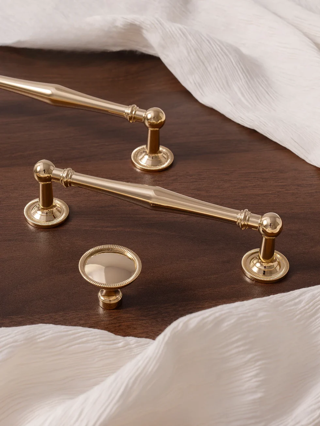 Set of gold cabinet handles on a wooden surface