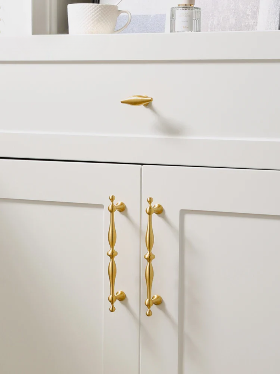 Collection of gold cabinet handles on a white background