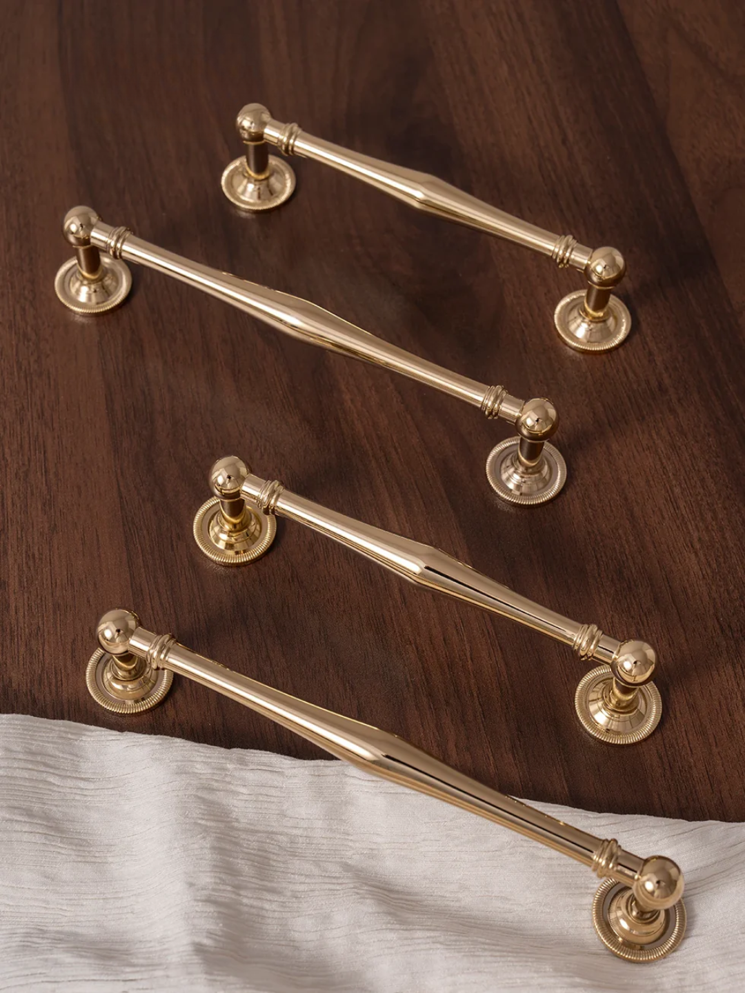 Set of gold cabinet handles on a wooden surface