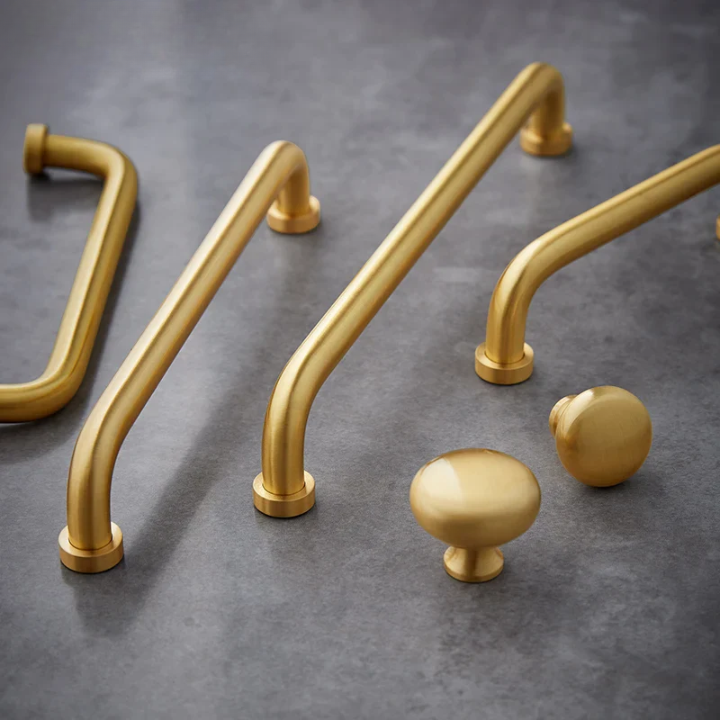 Gold cabinet handles and knobs on a dark gray surface