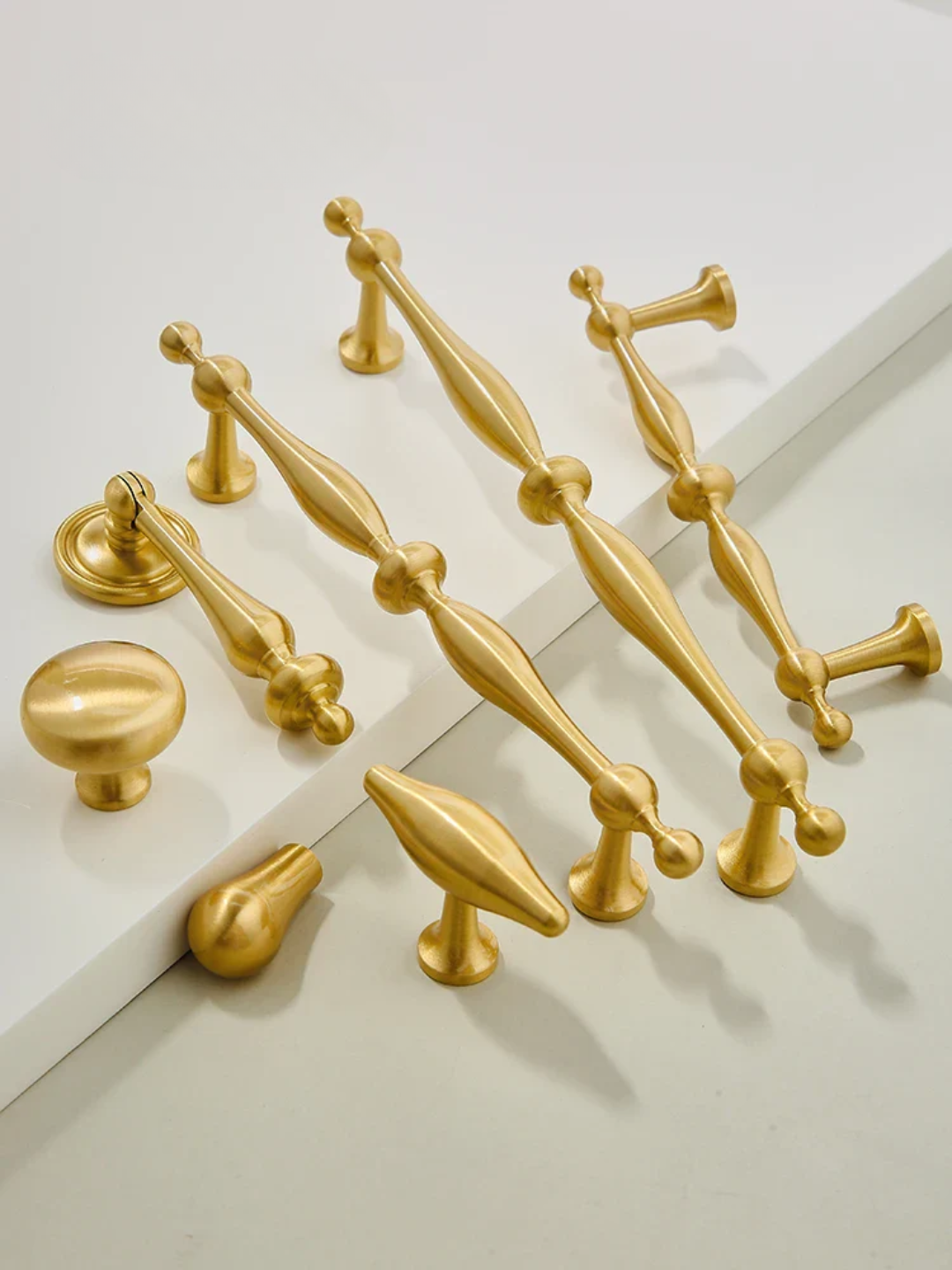 Collection of gold cabinet handles on a white background