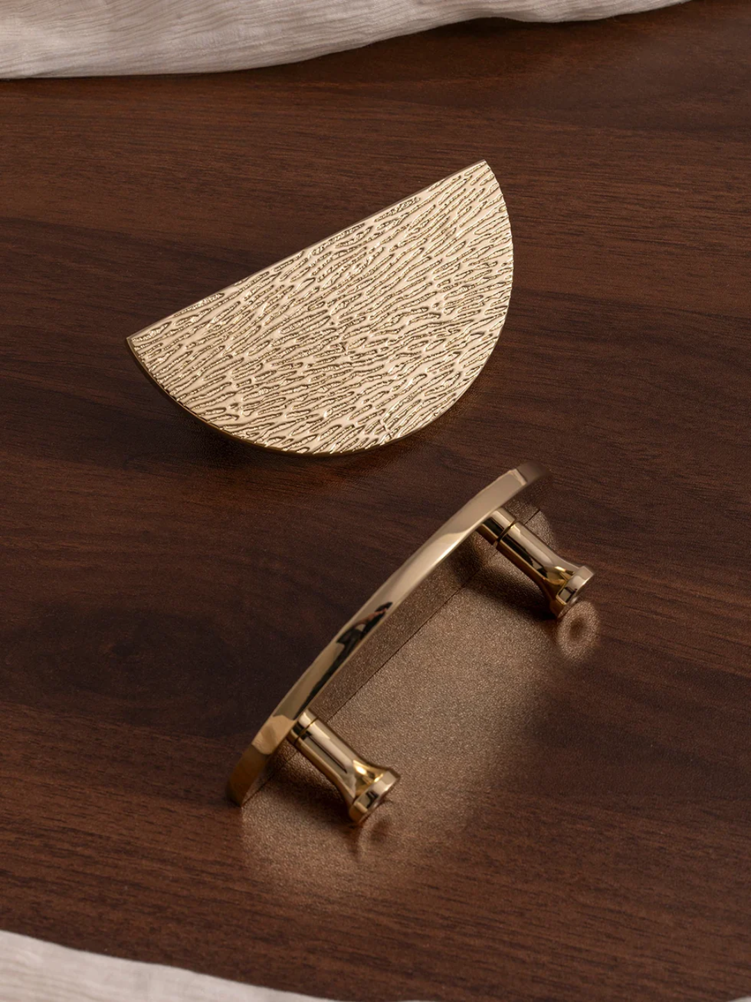 Gold half-circle drawer pull on a wooden surface