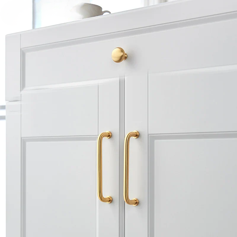 White cabinet with gold handles on a white background