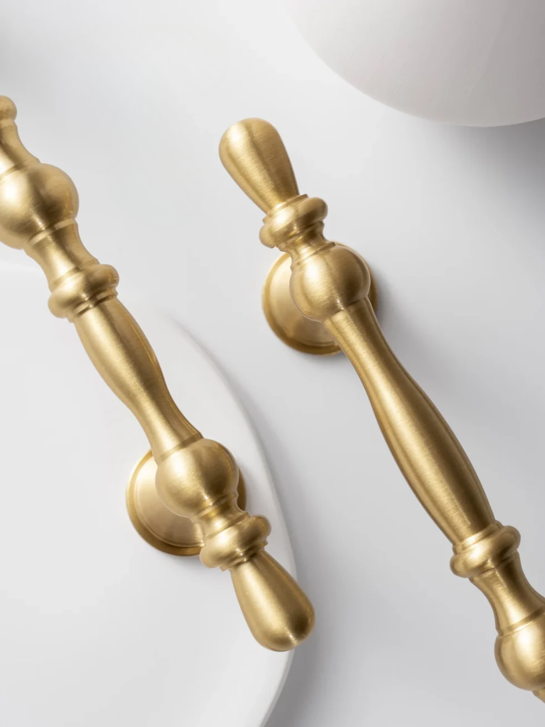 Gold cabinet handles on a white surface