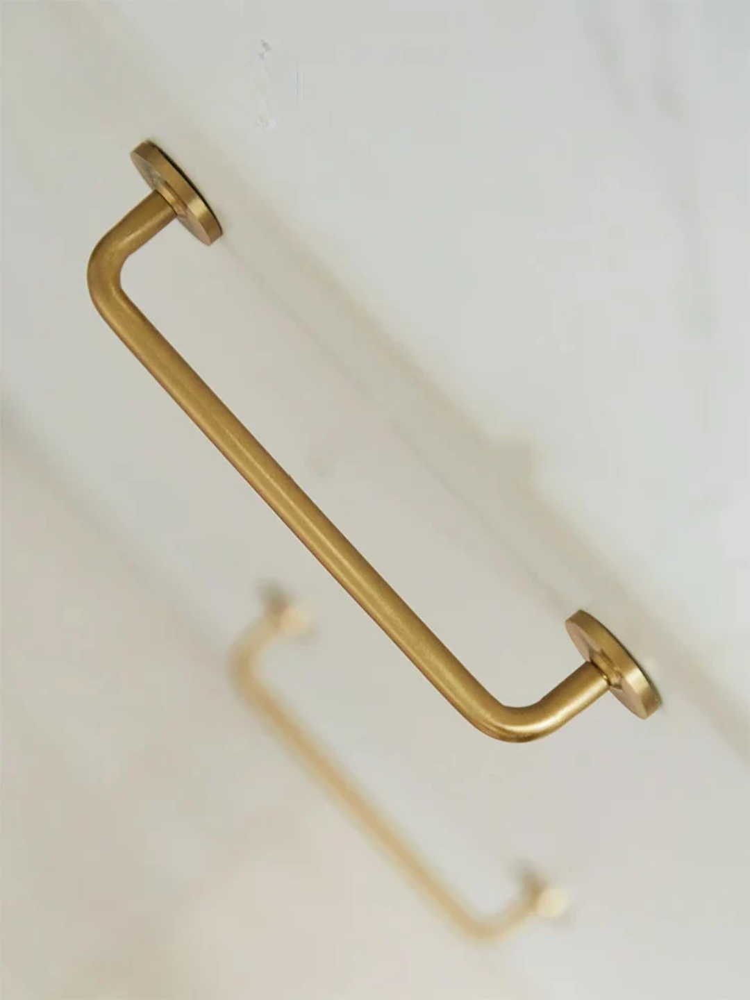 Gold towel bar on a white wall