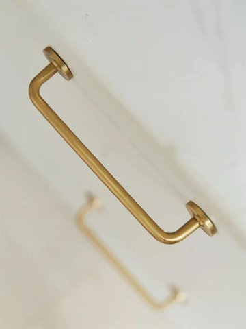Gold towel bar on a white wall