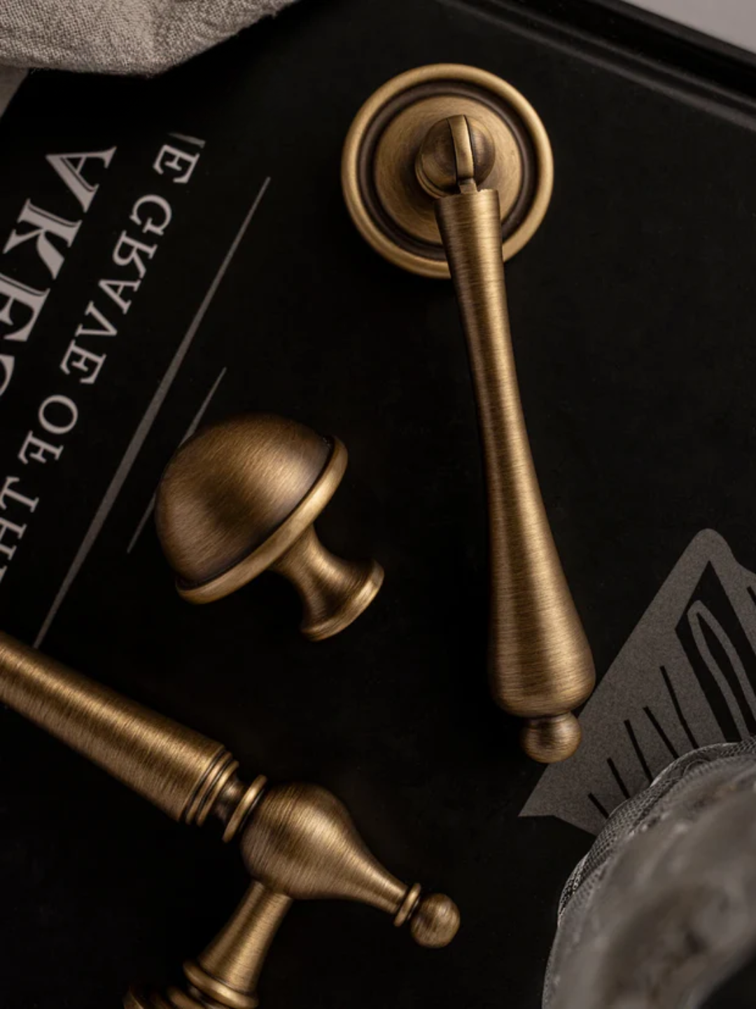 Bronze door handles on a dark surface with text and decorative elements.