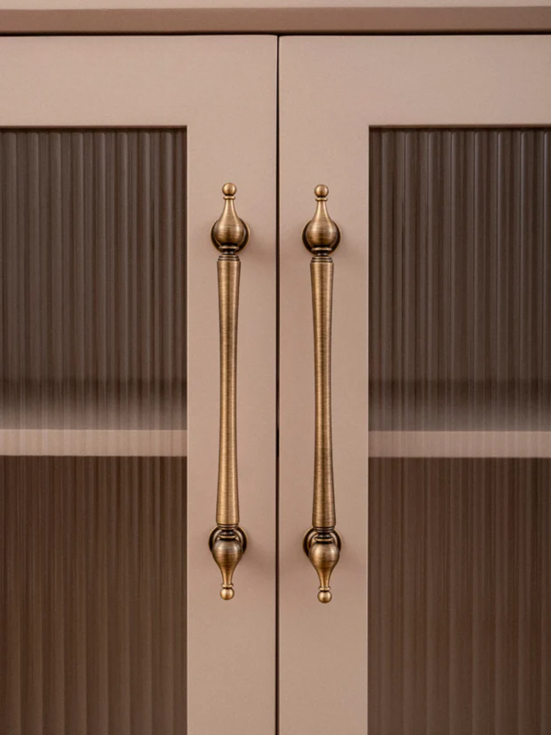 Cabinet doors with gold handles on a beige background