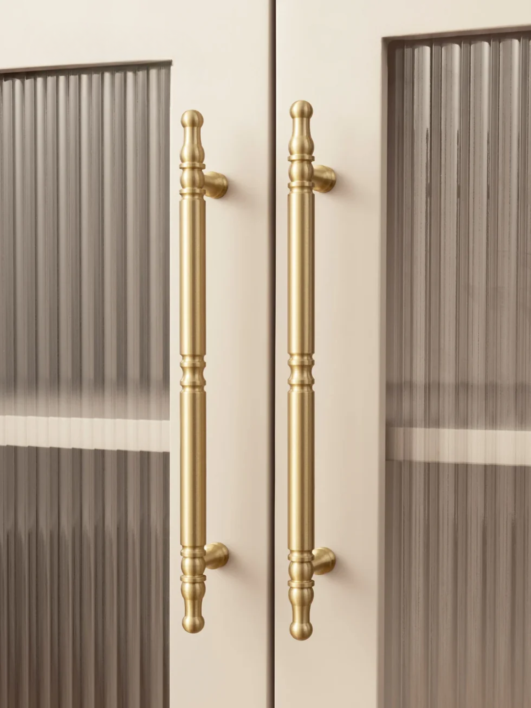 Close-up of a door with gold handles on a beige background