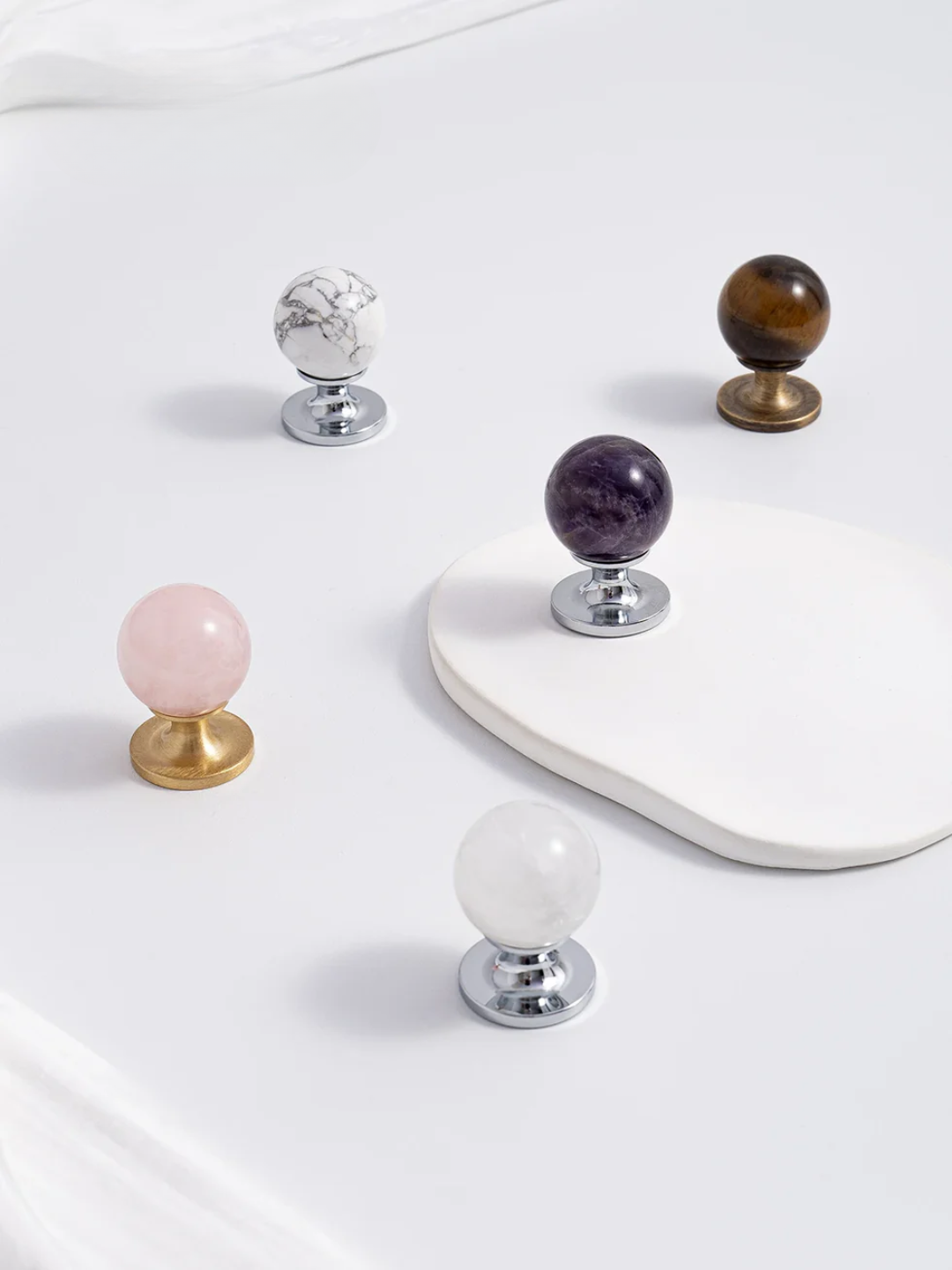 Set of decorative knobs with gemstone tops on a white surface