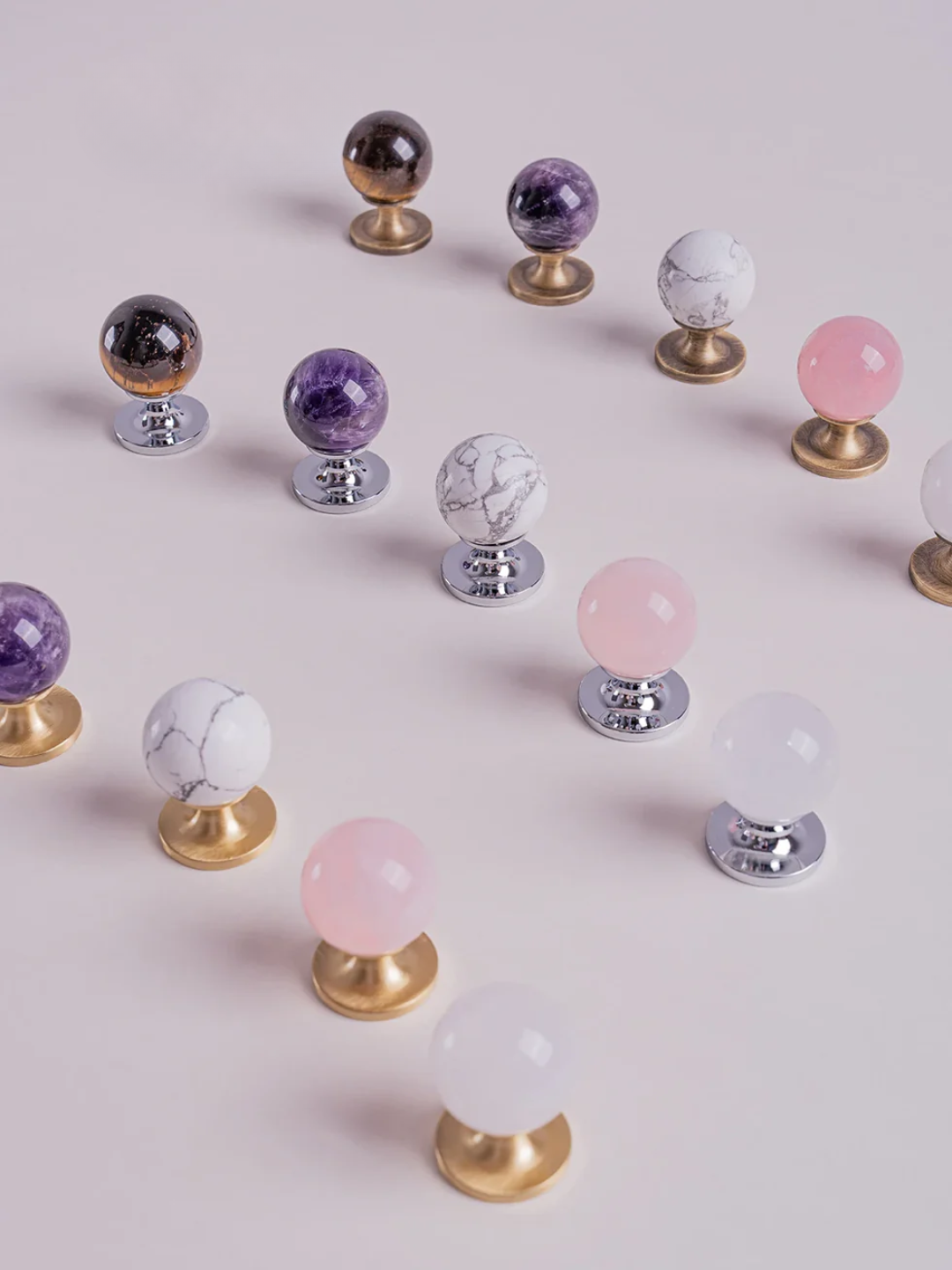 Decorative knobs with colorful spherical tops on a light pink background