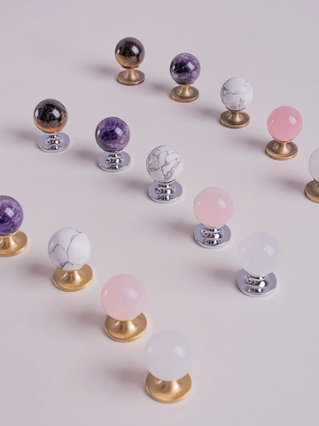 Decorative knobs with colorful spherical tops on a light pink background