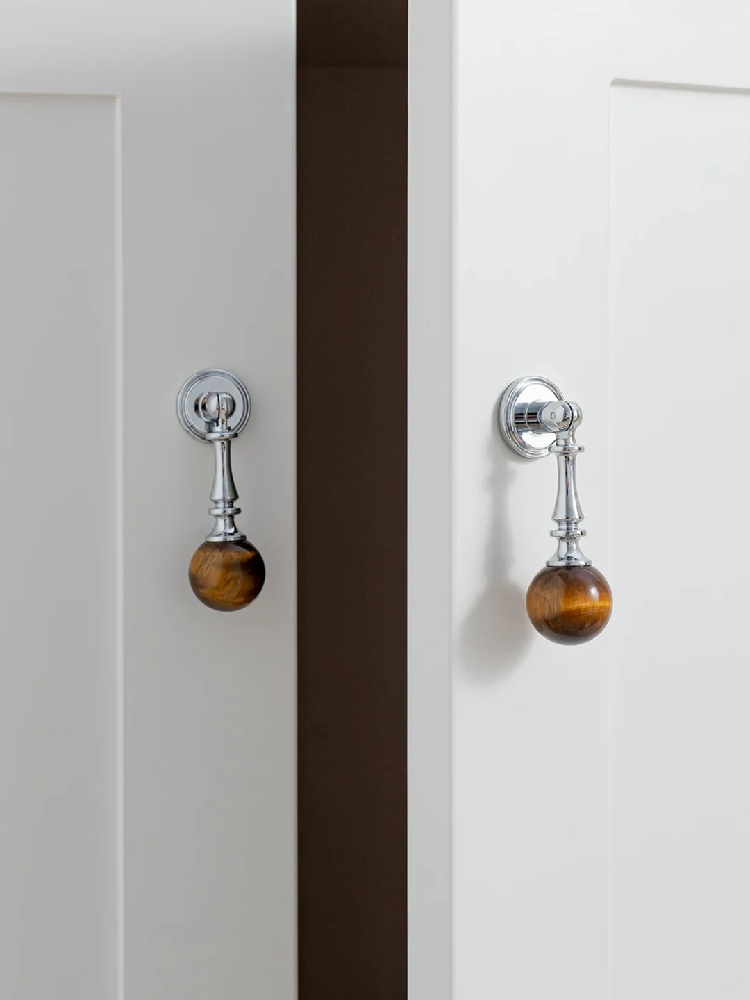 Close-up of two cabinet doors with decorative knobs on a white background
