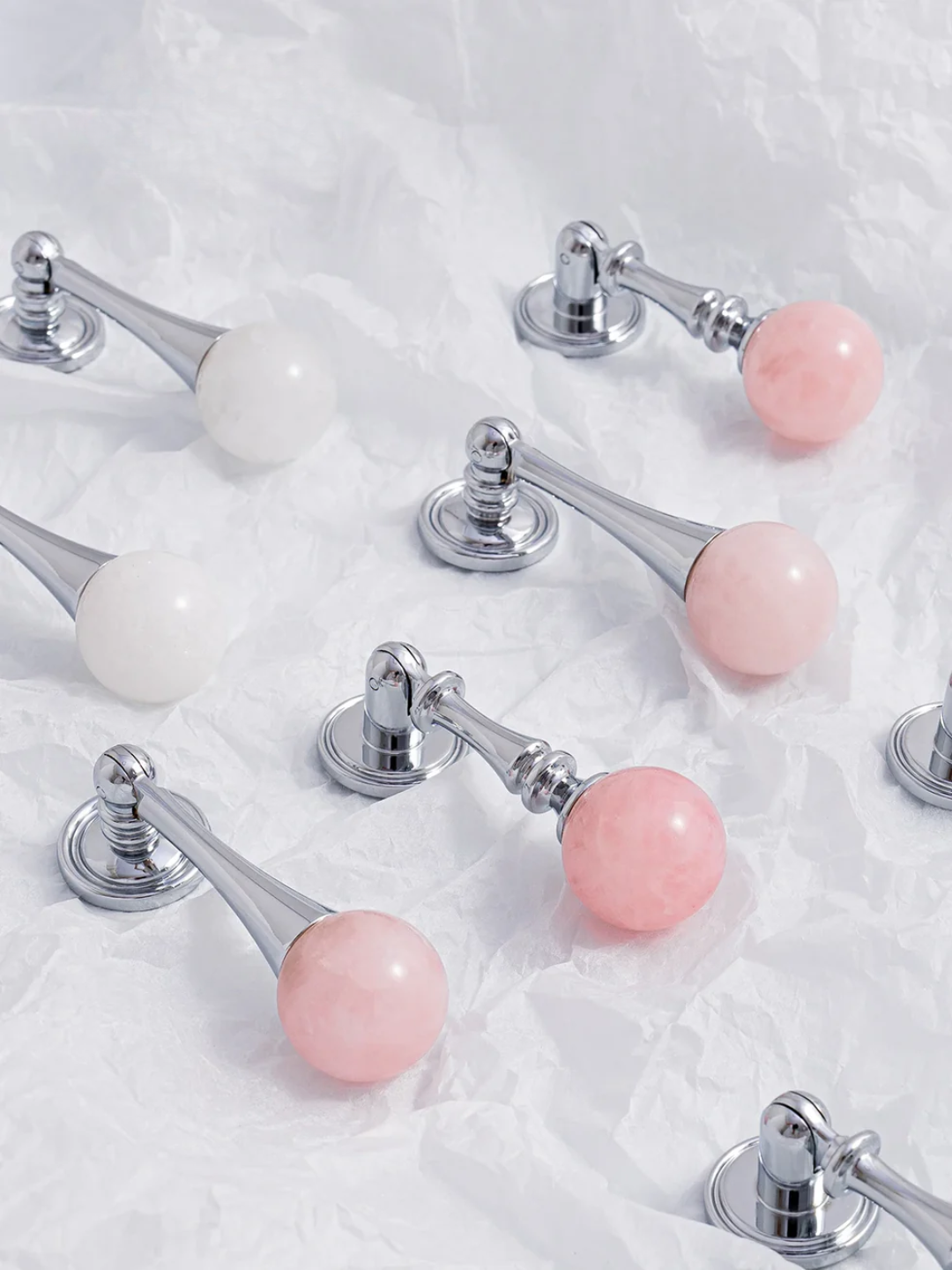 Set of door handles with pink and white knobs on a textured surface