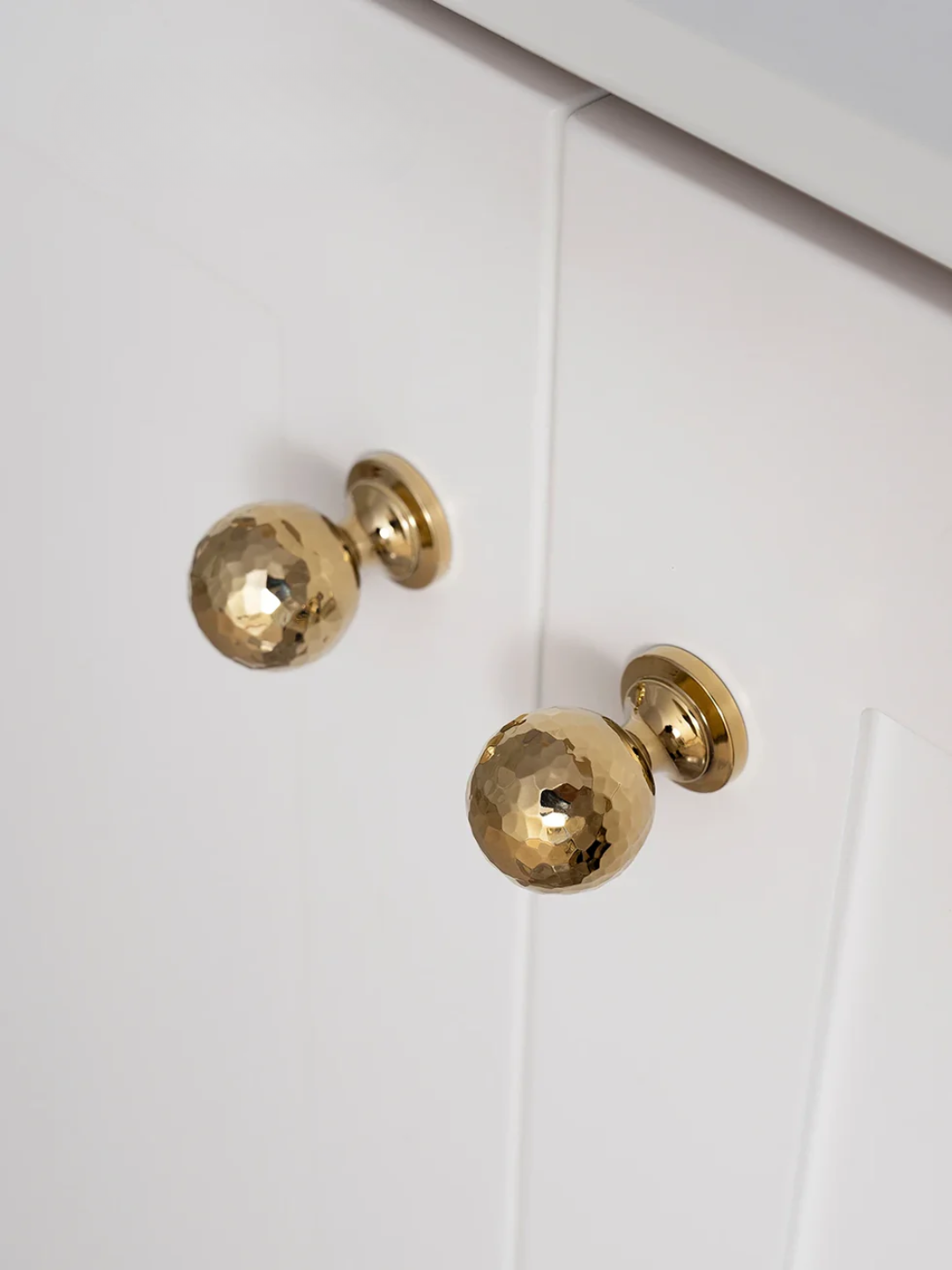Gold cabinet knobs on a white cabinet