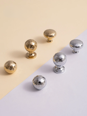 Gold and silver metallic knobs on a beige and white background