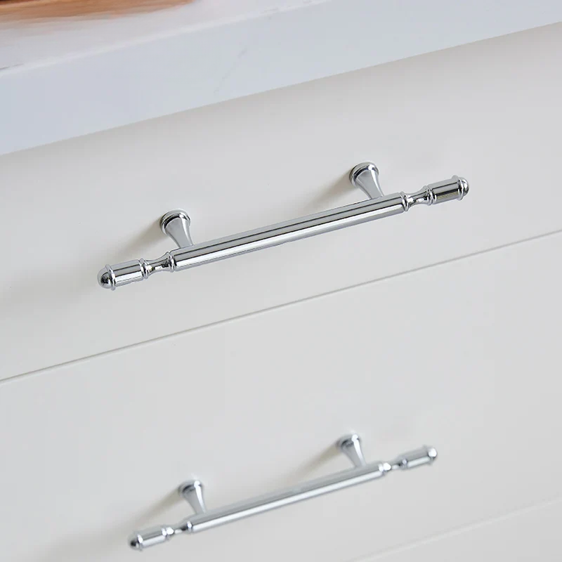Chrome cabinet handles on a white cabinet door