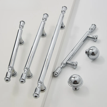 Set of chrome cabinet handles and knobs on a light gray background