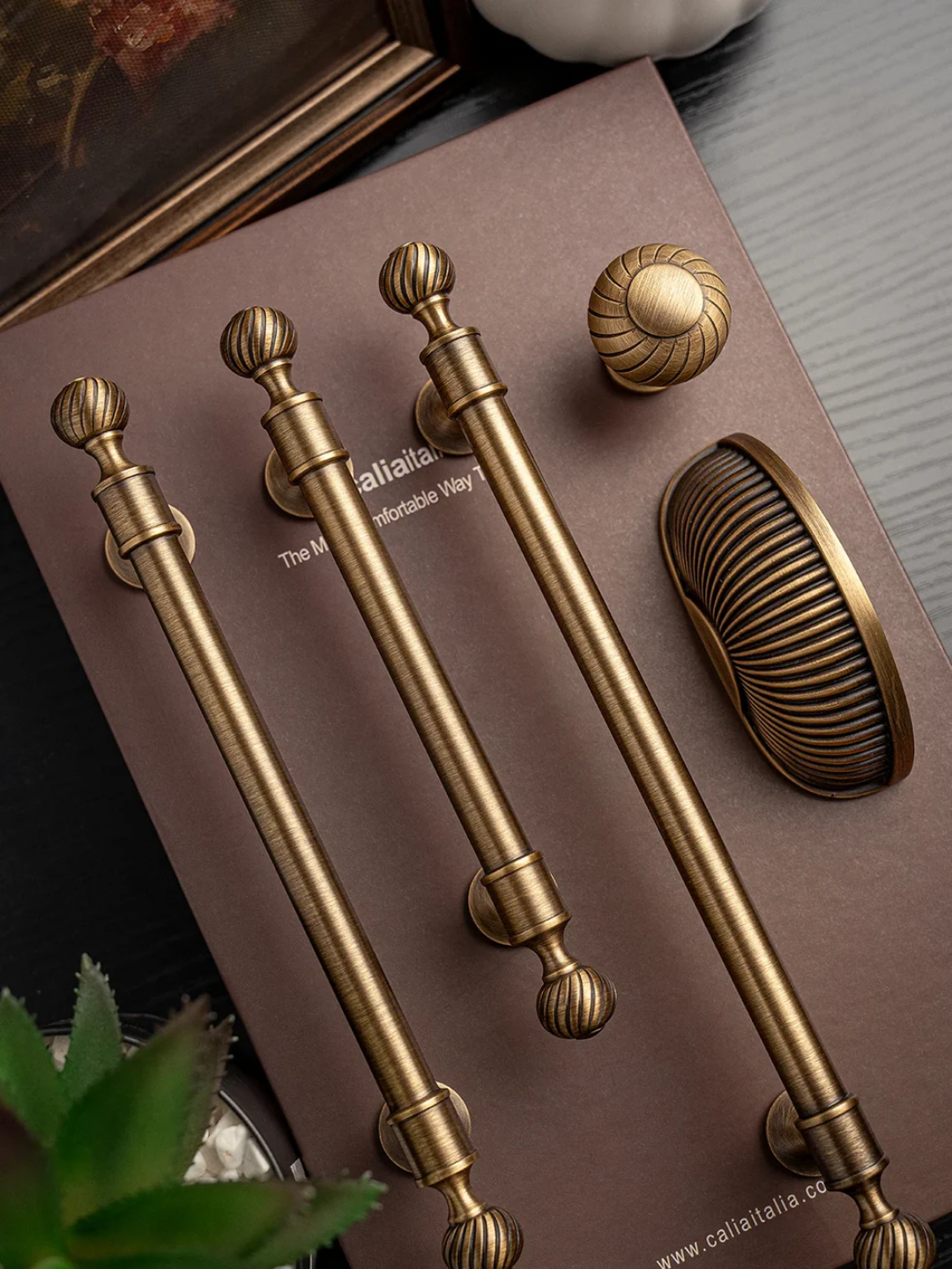 Set of gold cabinet handles and knobs on a brown surface with 'Callista' branding.
