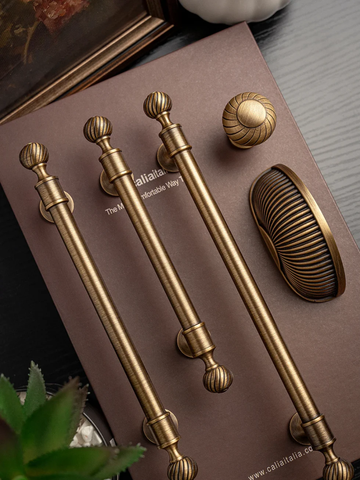 Set of gold cabinet handles and knobs on a brown surface with 'Callista' branding.