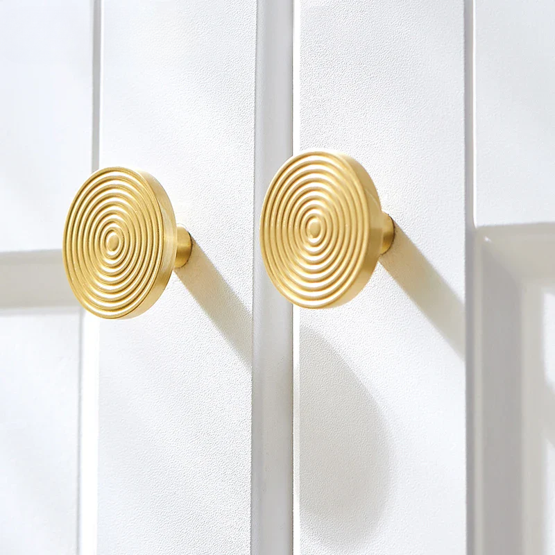 Gold spiral design handles on a white door