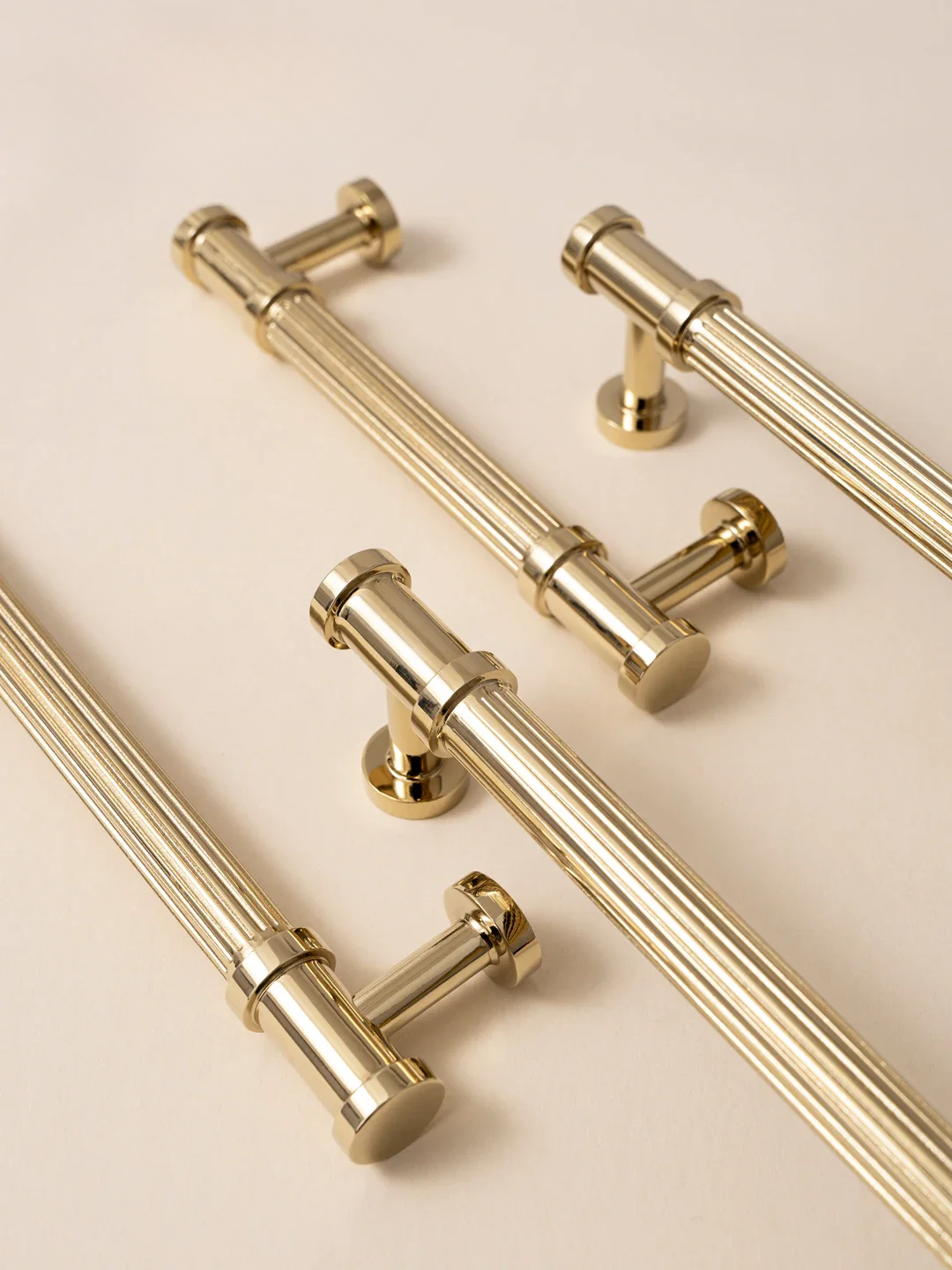 Set of gold cabinet handles on a beige background