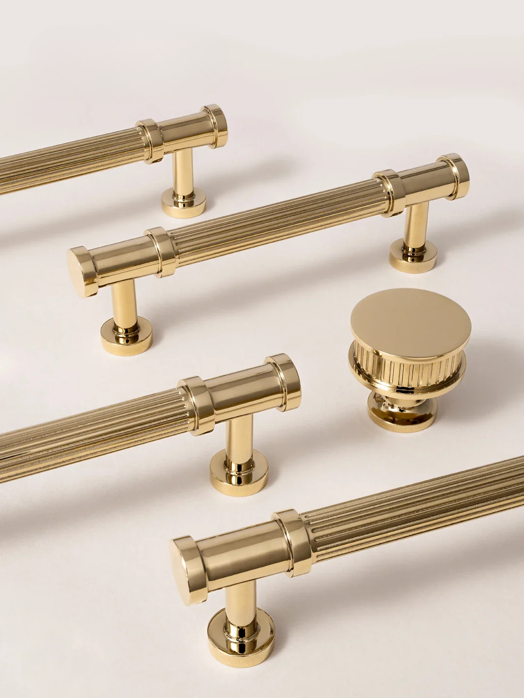 Set of gold cabinet handles and knobs on a light background