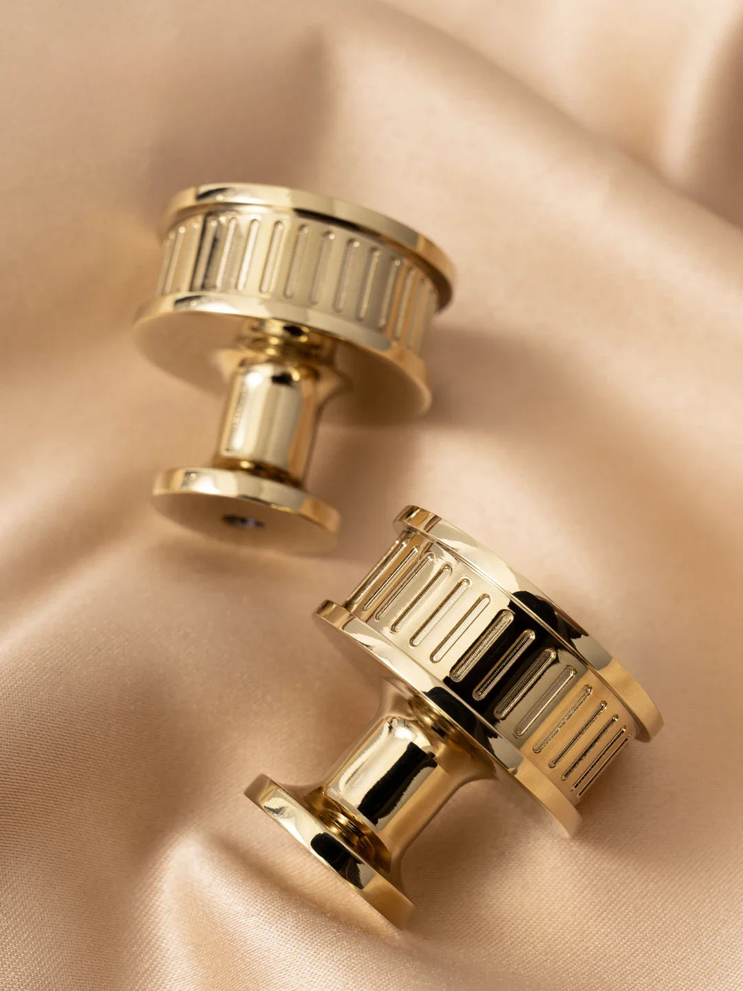 Gold cufflinks on a beige fabric background
