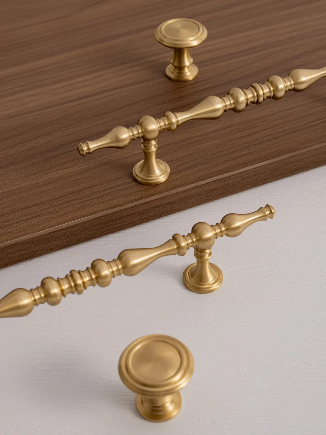 Gold cabinet handles and knobs on a wooden surface