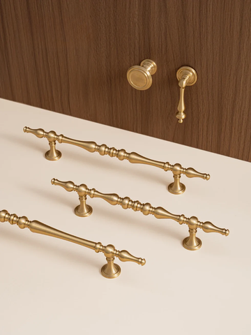 Set of gold cabinet handles on a wooden surface