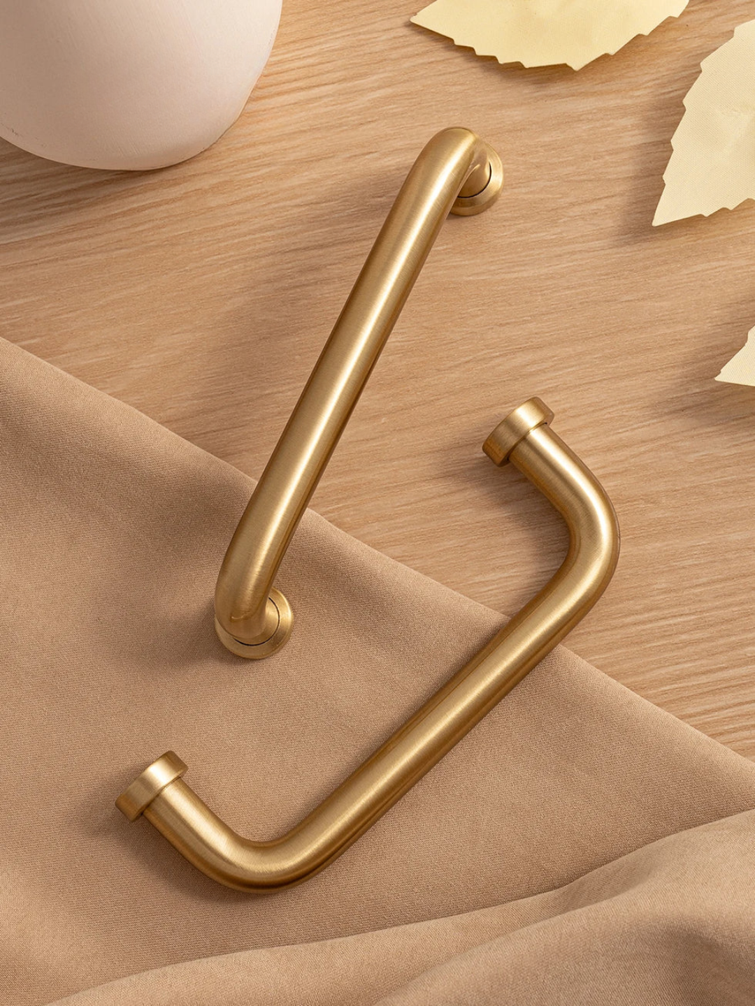 Gold handles on a wooden surface with a soft fabric background