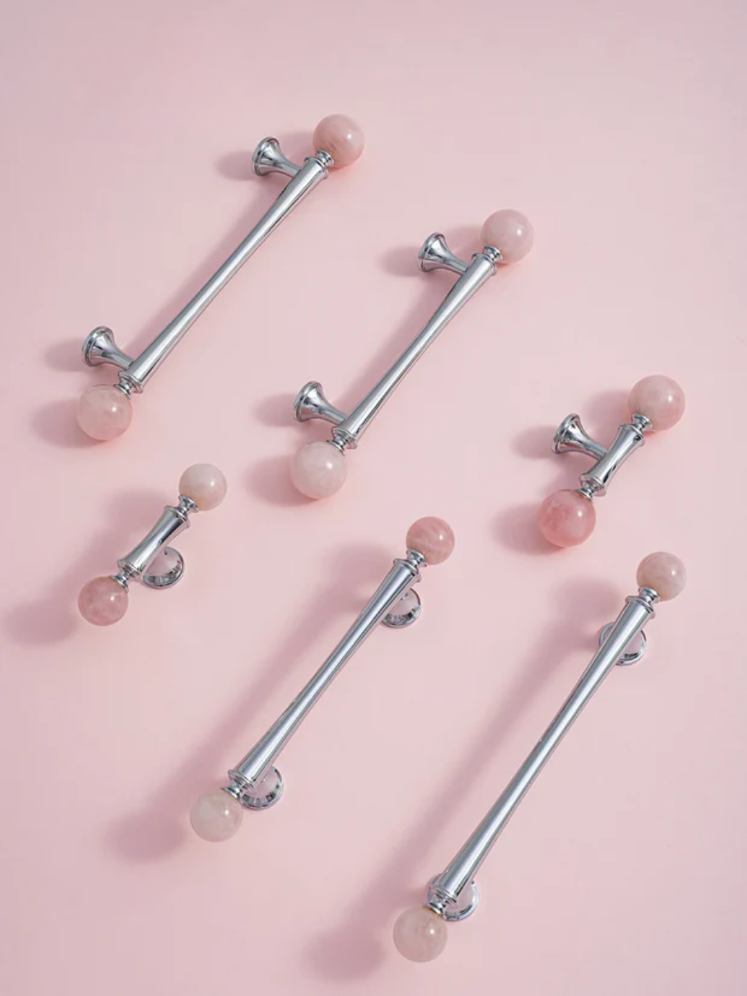 Belly button rings with pink gemstones on a pink background