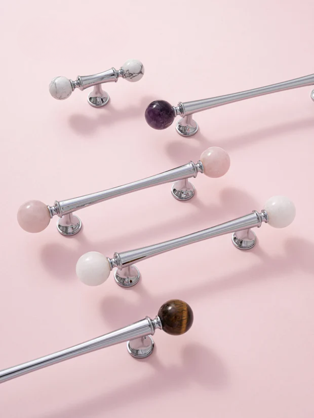 Decorative curtain rods with colorful knobs on a pink background
