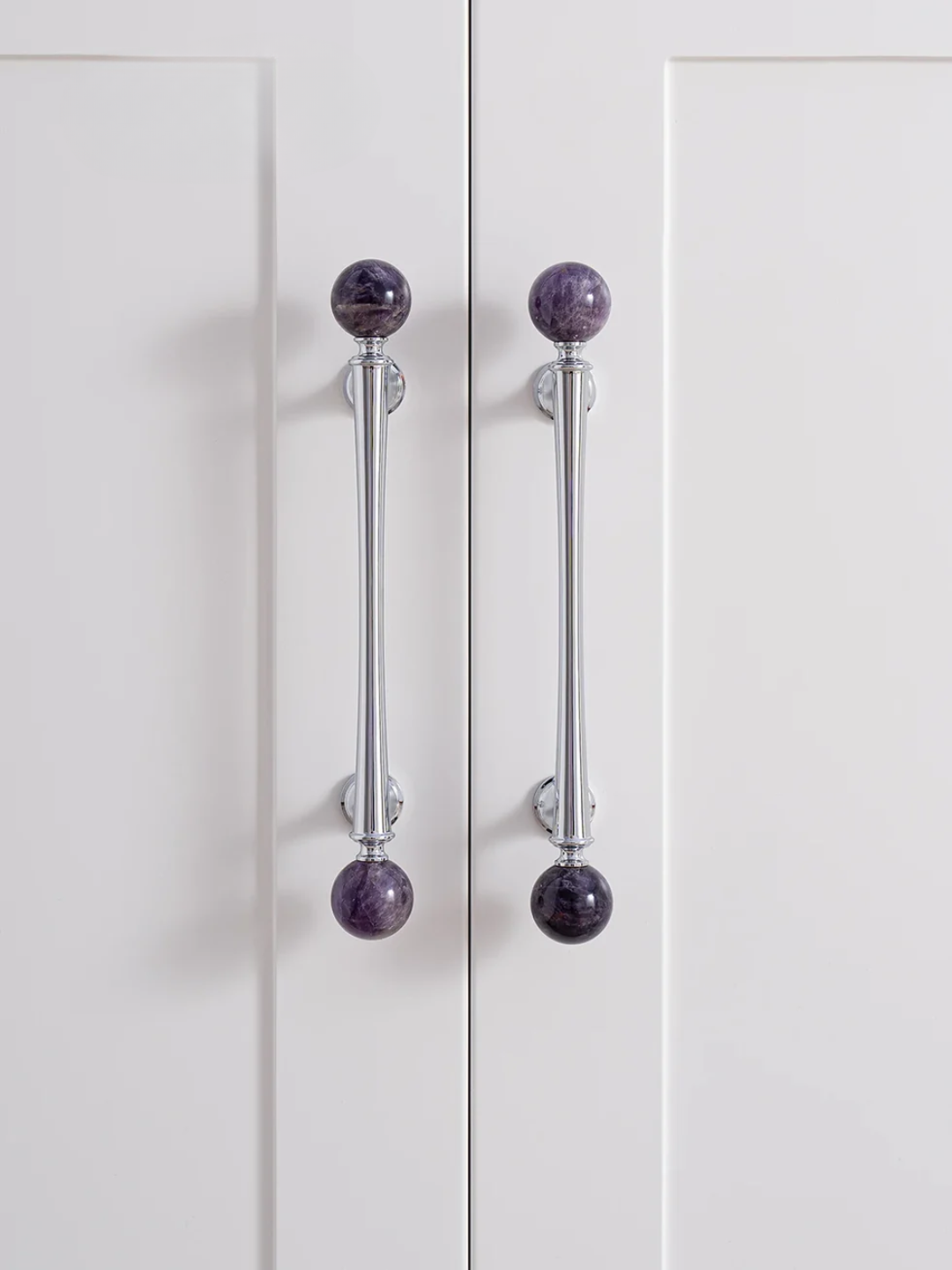 Cabinet doors with pink knobs on a neutral background
